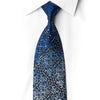 San-Dee navy silk necktie knotted against a white shirt, with cobalt and silver scrollwork, crystal rhinestones, and small gold-toned accents.
