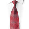 A red necktie with a geometric star pattern in white and light blue, styled on a white dress shirt collar.